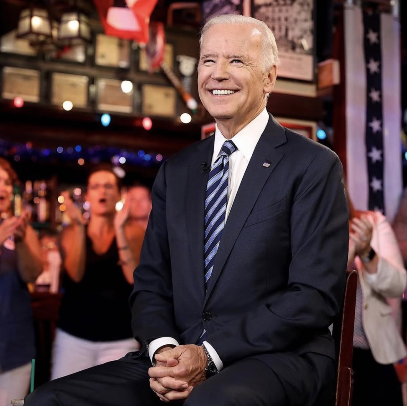 Then–Vice President Joe Biden smiles in front of a cheering crowd and bunting.