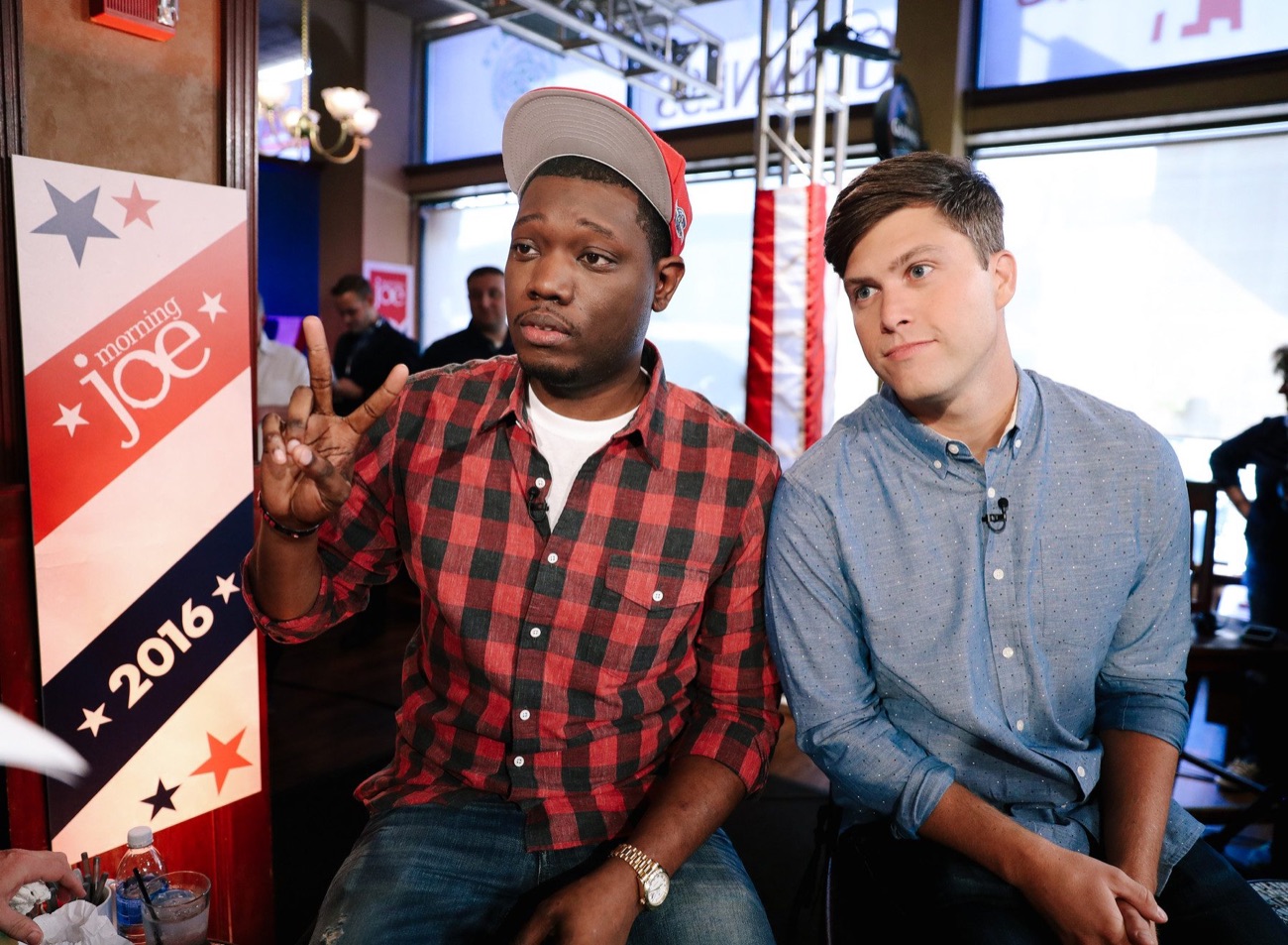 Michael Che and Colin Jost seated on the Morning Joe set.